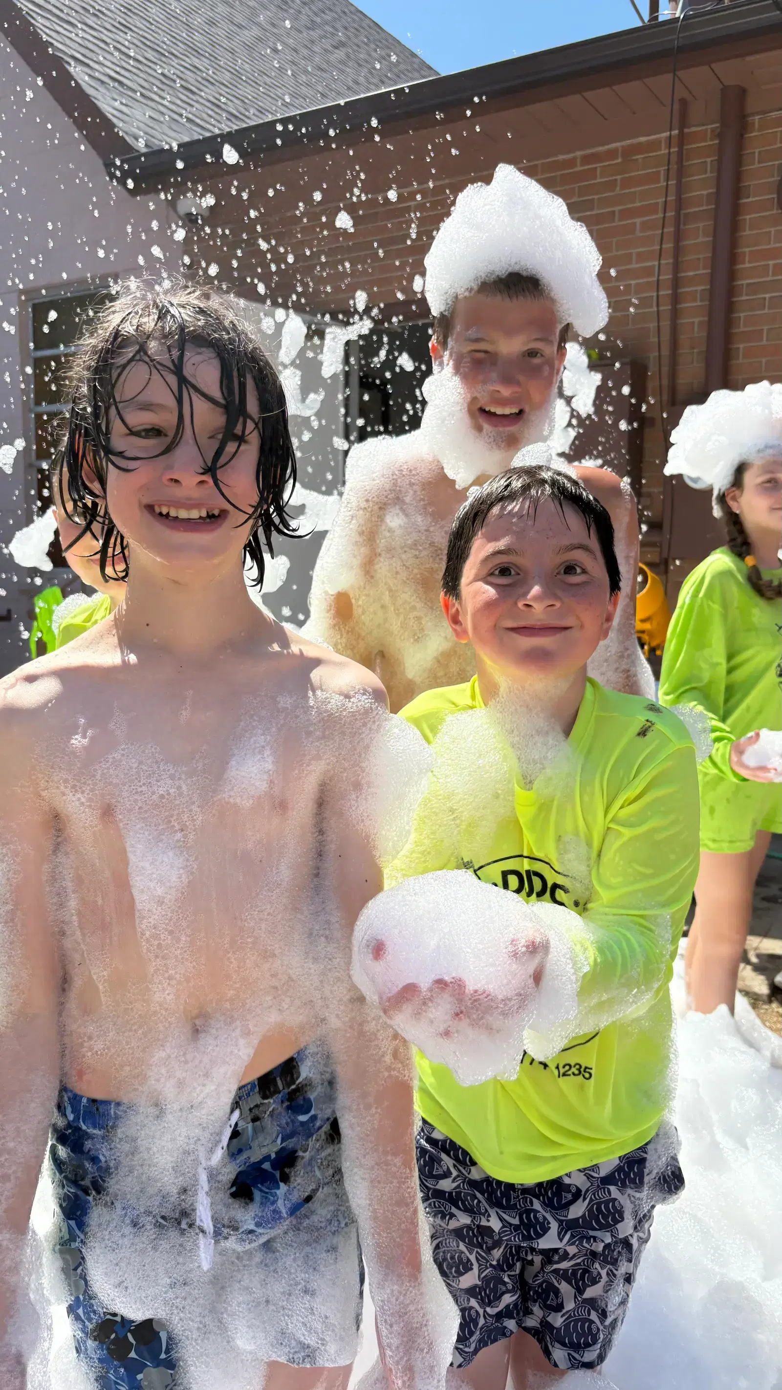 Two campers covered in foam, laughing, at the camp foam party