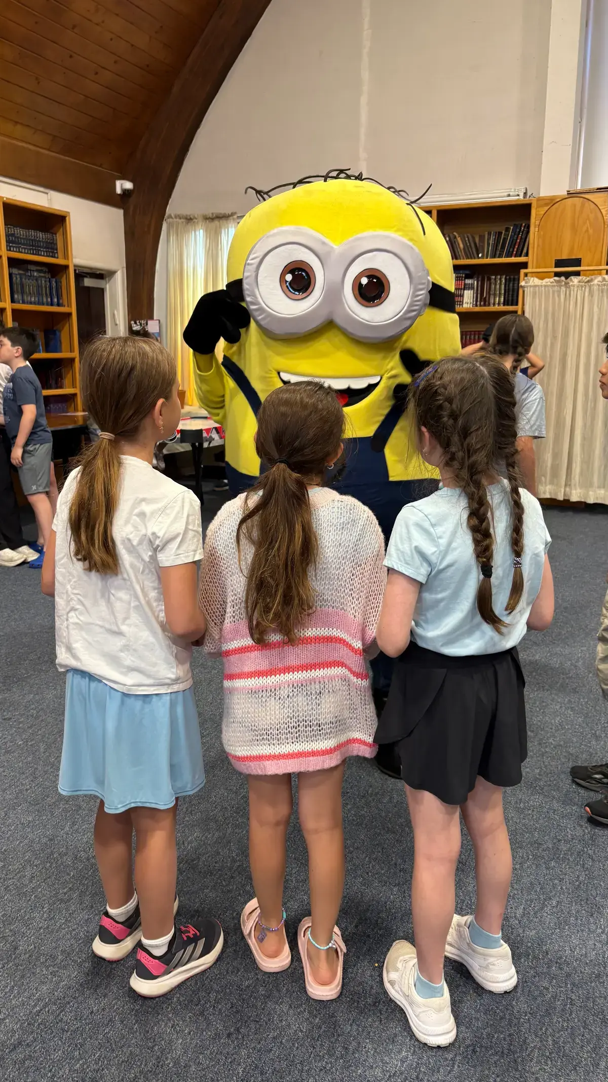 A giant Minion character visiting campers