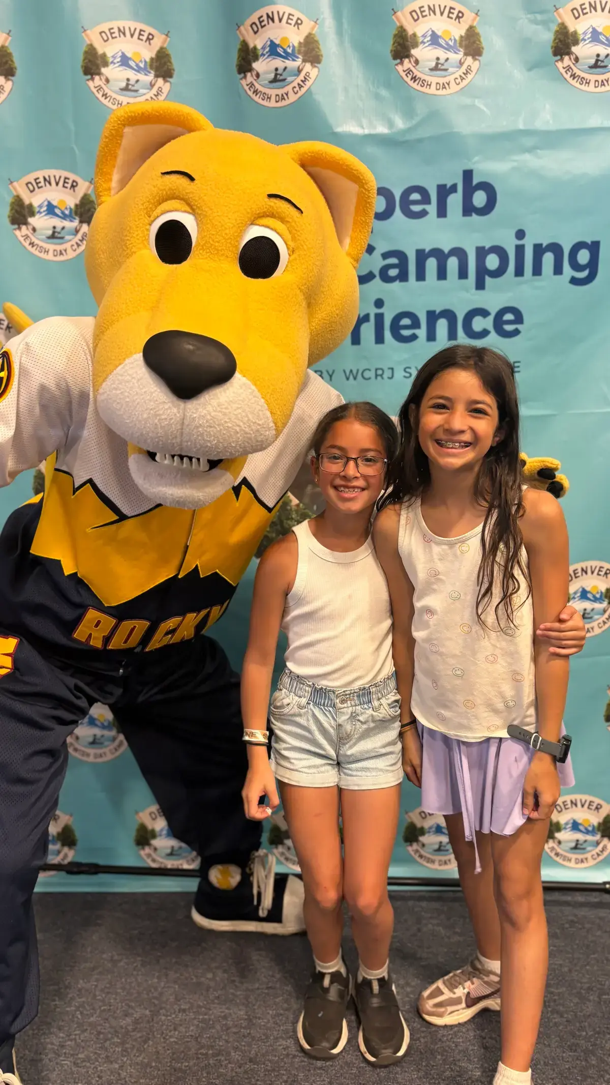 Two campers posing with Rocky, the Denver Nuggets mascot