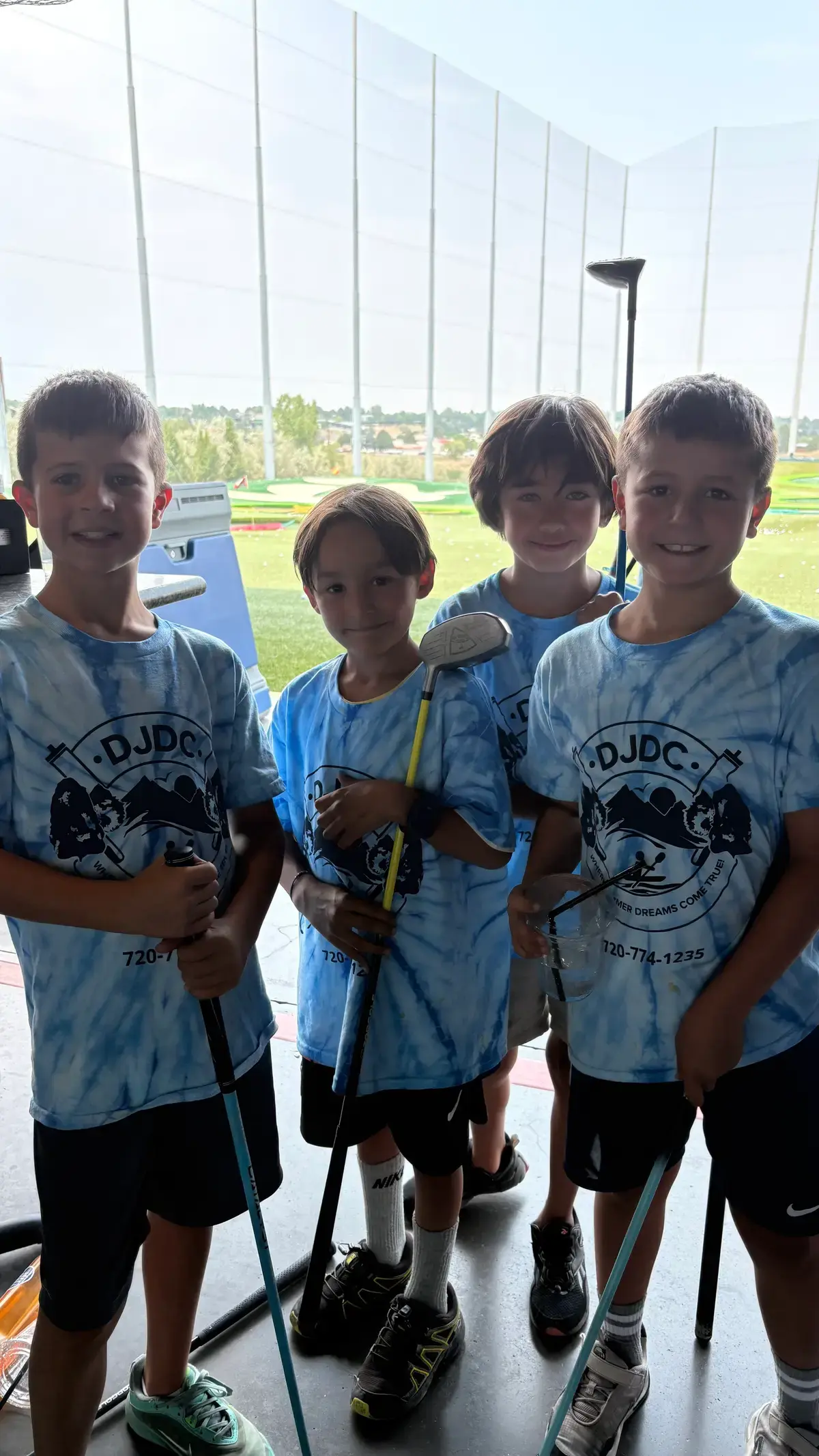 Campers with clubs at the Topgolf bay on a trip day